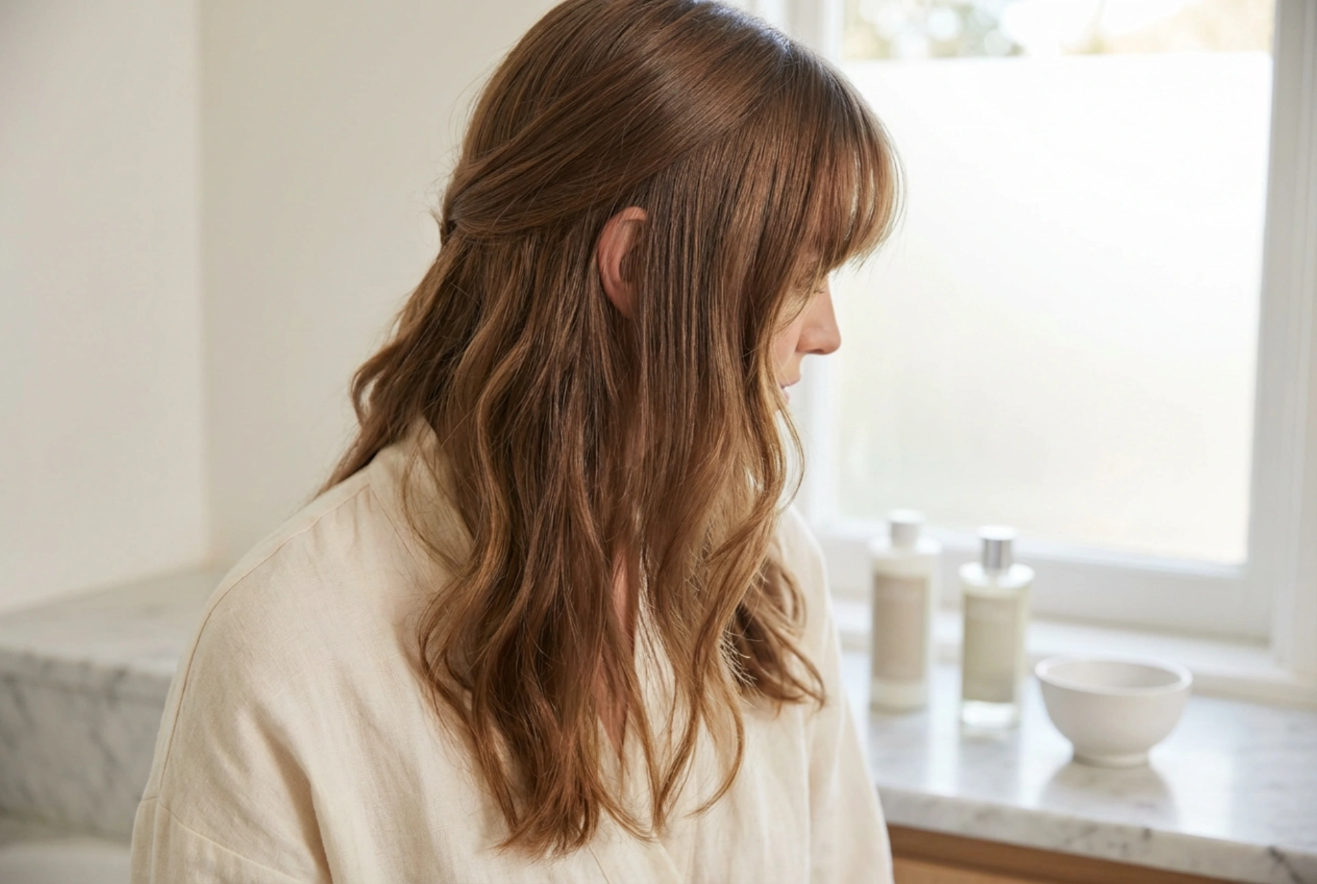 Long hair with a fringe: how to combine a parting, waves, and smoothing